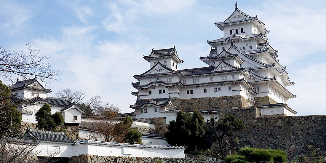 a big  white castle in a Japanese stile with pagodas